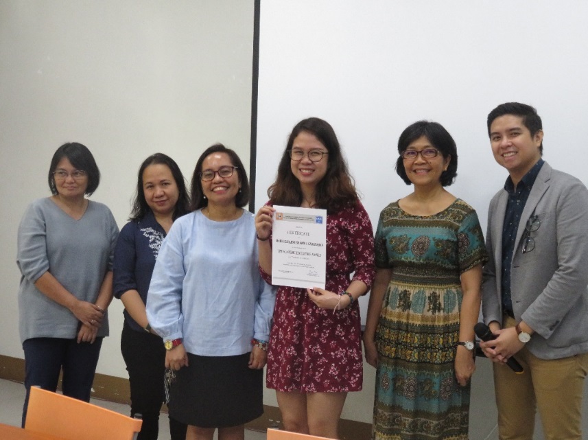 Ms. Cabaraban beams as she holds her certificate. Flanking her are, from left to right, Prof. Maria Marquez, Dr. Elma Laguna, Dr. Nimfa Ogena, Dr. Grace Cruz, and Mr. Michael Del Mundo